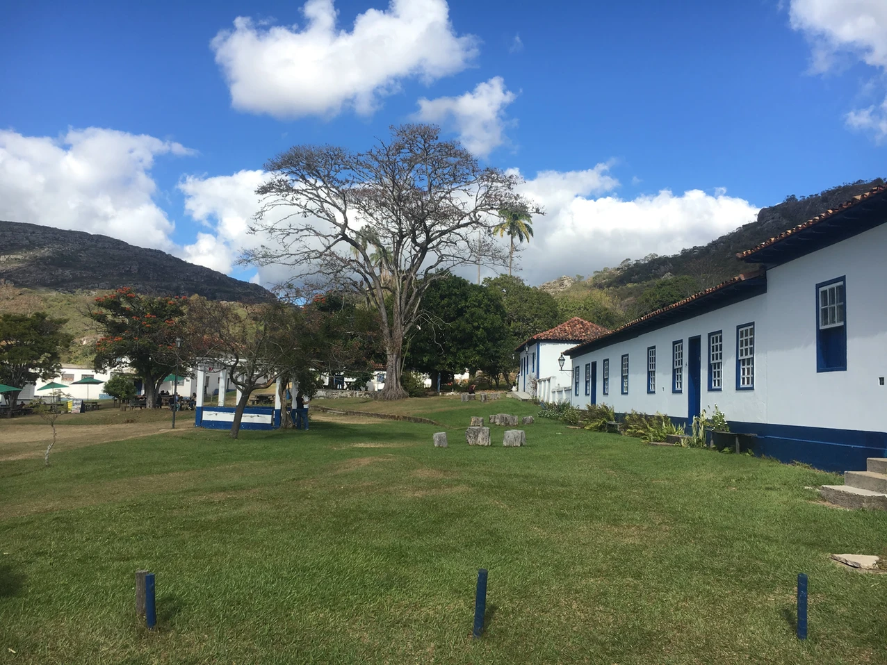 Vista ampla do vale da Cachoeira dos Cristais com rochas avermelhadas e cerrado